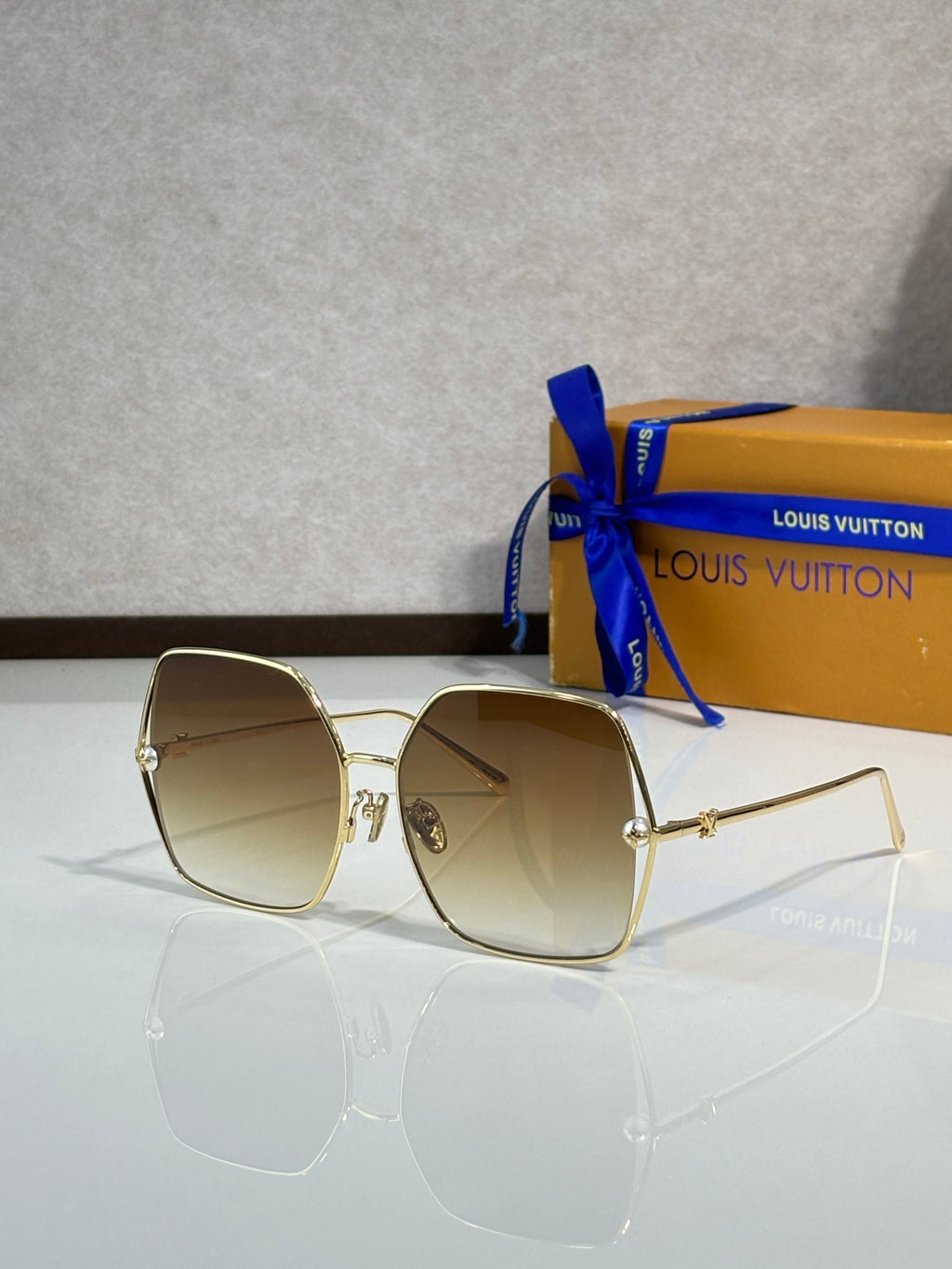 Louis Vuitton sunglasses with gold-tone frame and light beige tinted lenses