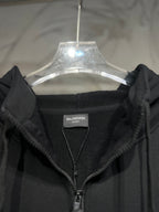 Black zip-up hoodie with hood and front zipper, shown with brand tag.