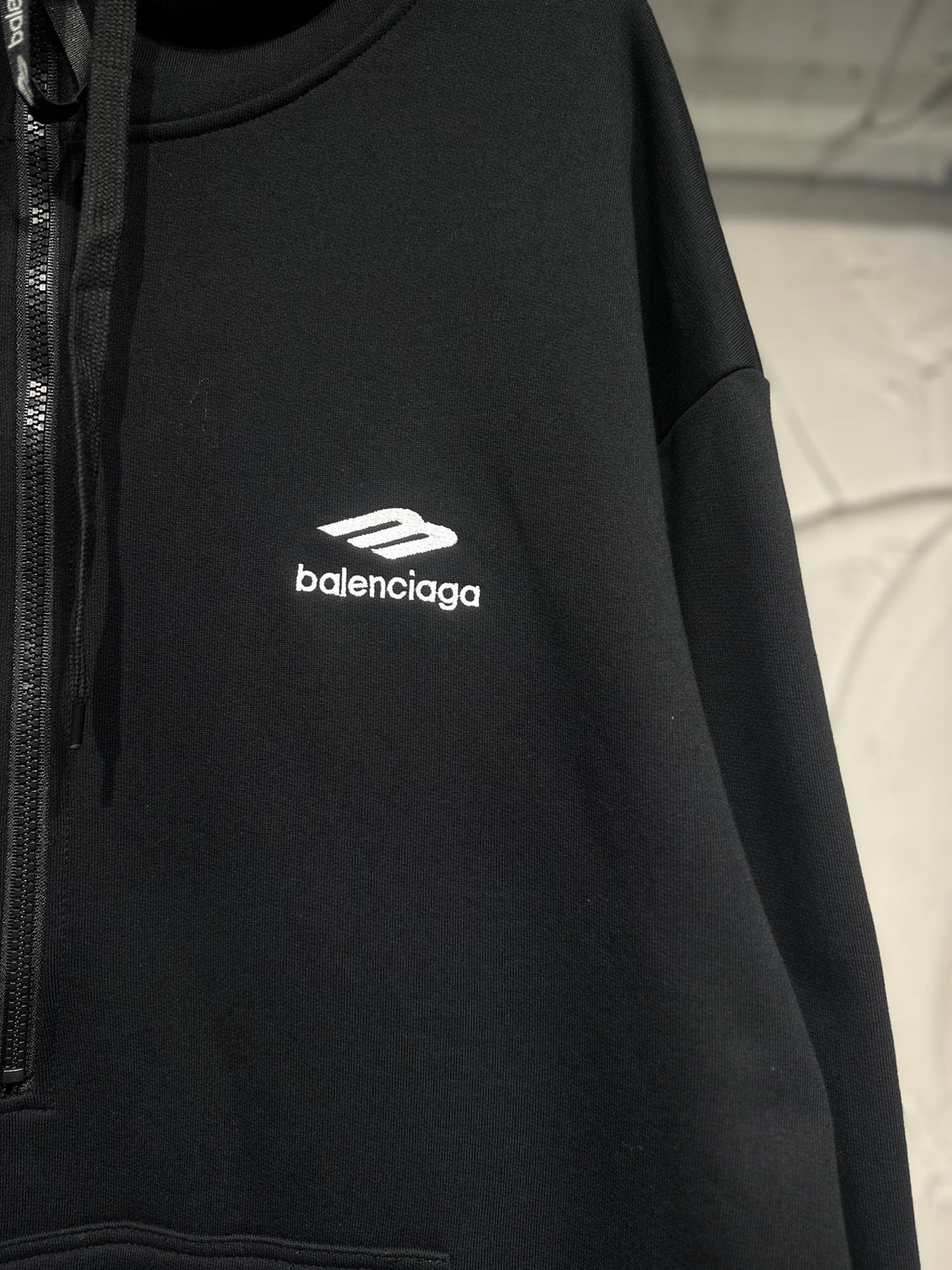 Black Balenciaga hoodie with white chest logo and drawstring hood.