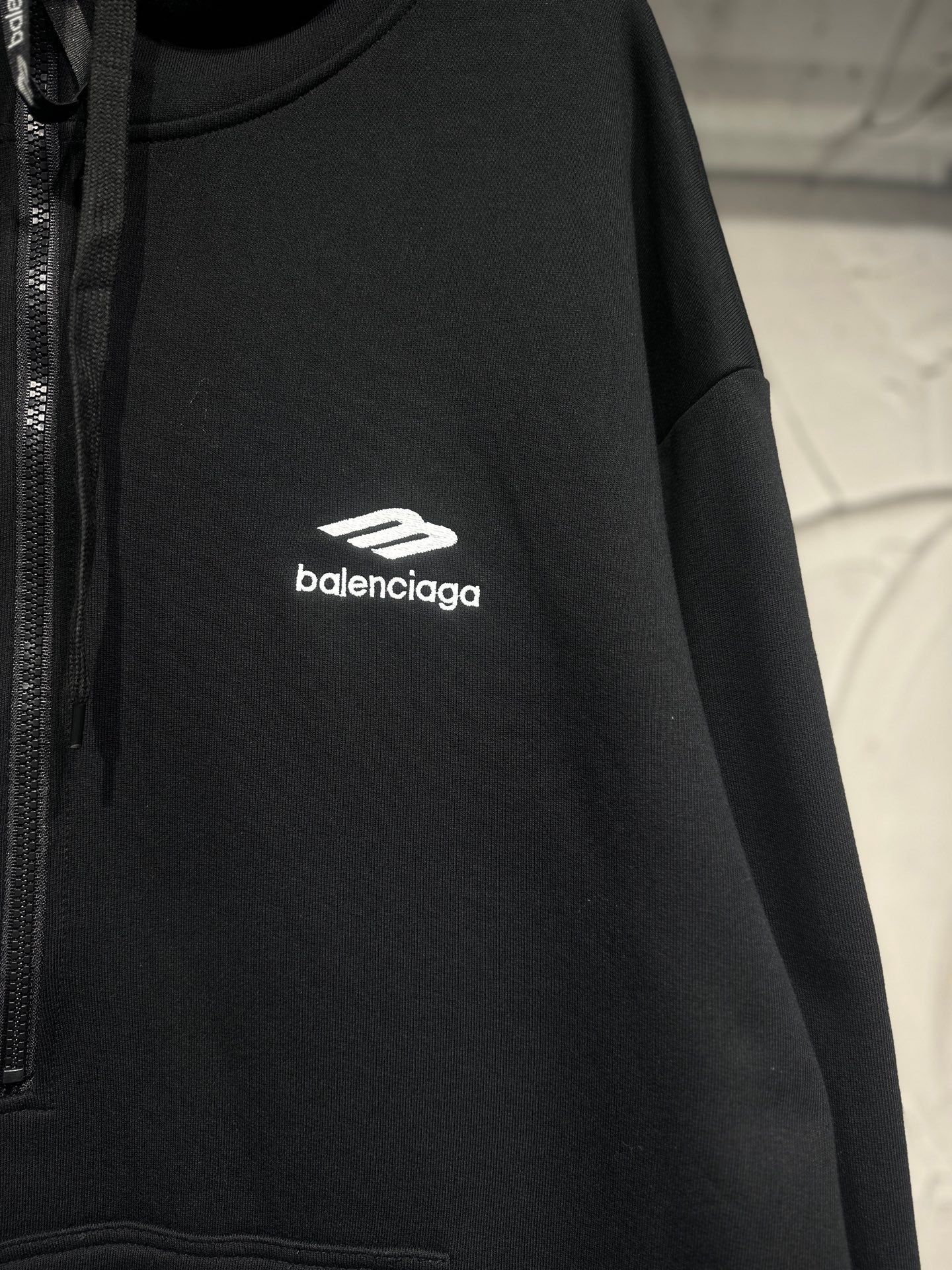 Black Balenciaga hoodie with white chest logo and drawstring hood.