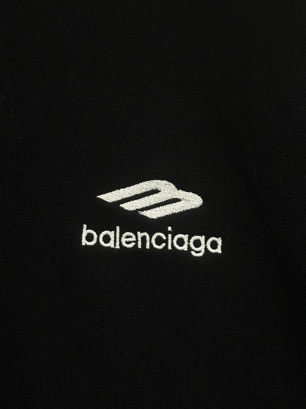 Balenciaga white logo print on black hoodie fabric.
