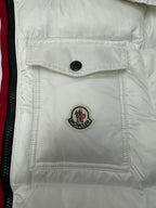 White puffer jacket chest pocket with black button and Moncler emblem