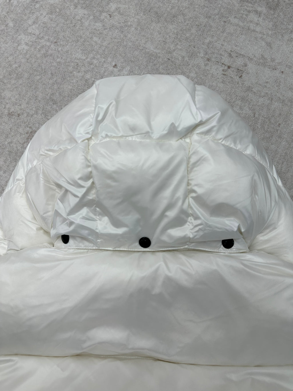White puffer jacket hood with snap buttons at front opening