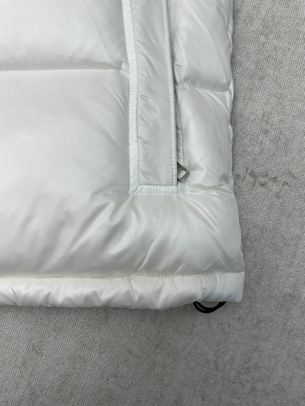 White puffer jacket sleeve cuff and padded hem with buttoned pocket
