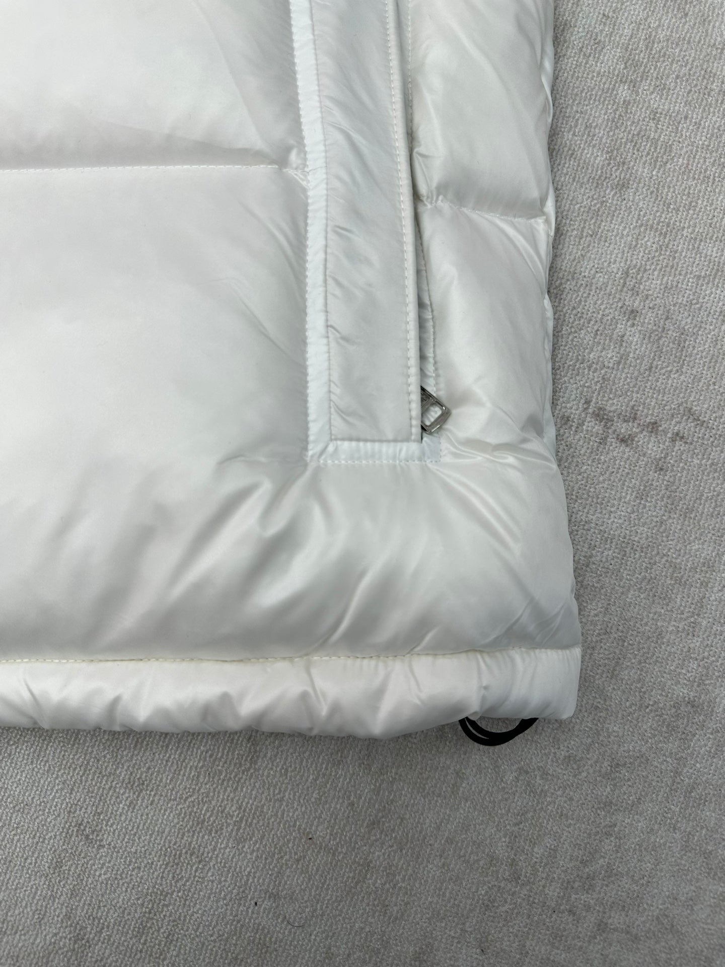 White puffer jacket sleeve cuff and padded hem with buttoned pocket