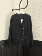 Black knit cardigan with V-neck, button front, and flap pockets