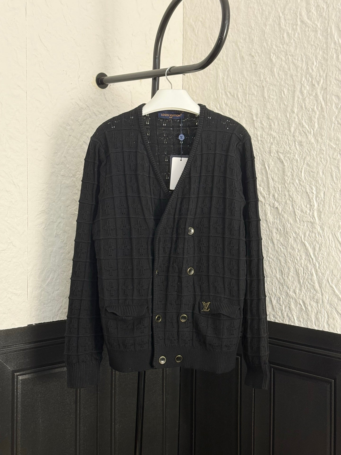 Black knit cardigan with V-neck, button front, and flap pockets