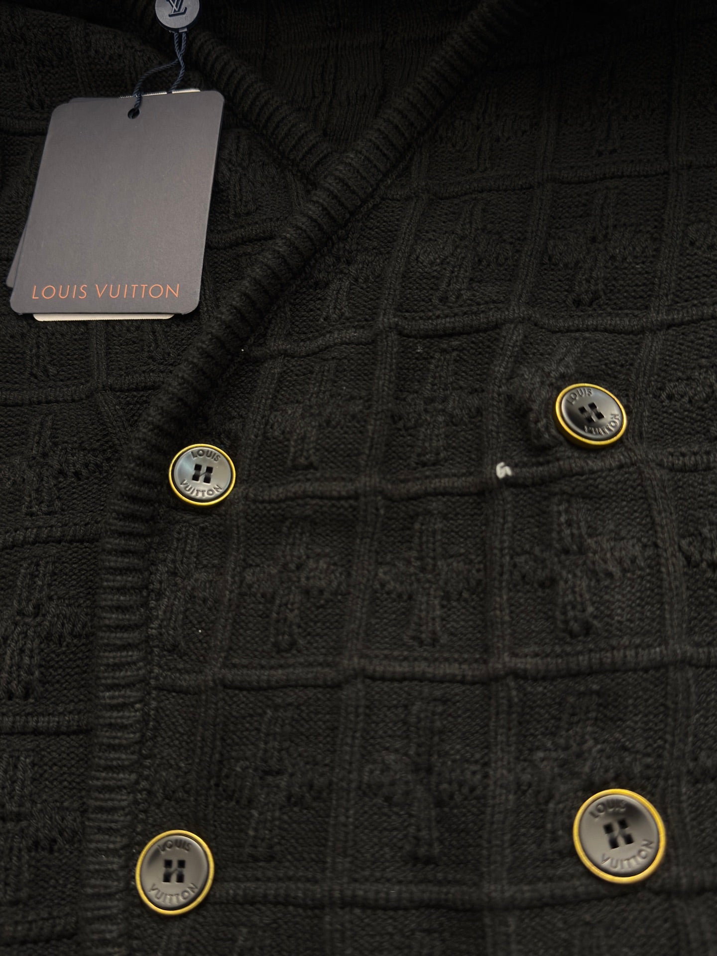 Black knit cardigan with textured pattern and gold-tone button accents