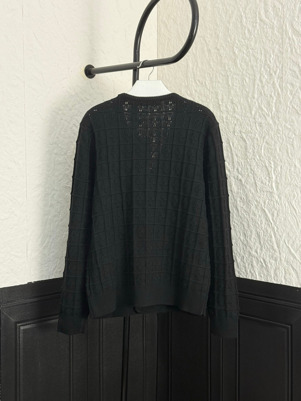 Back of black knit cardigan with button placket and structured yoke