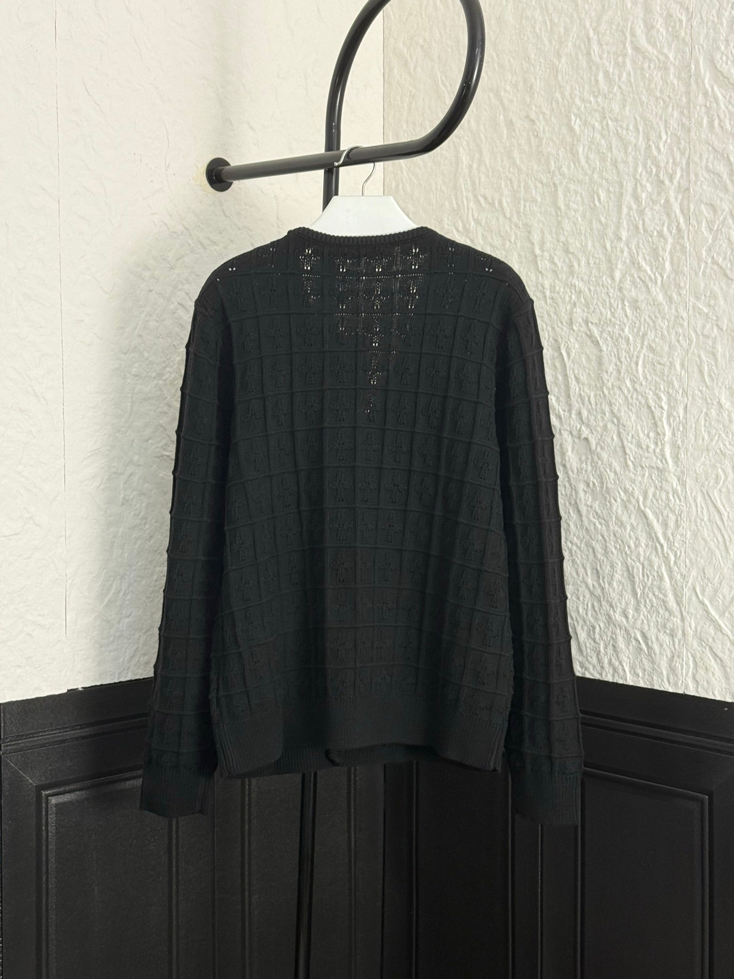 Back of black knit cardigan with button placket and structured yoke