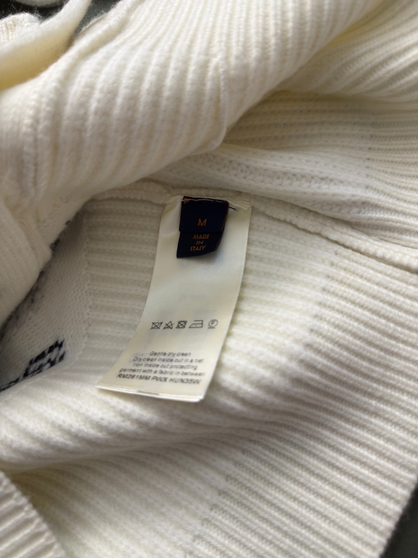 Cream rib-knit cardigan interior with care label visible