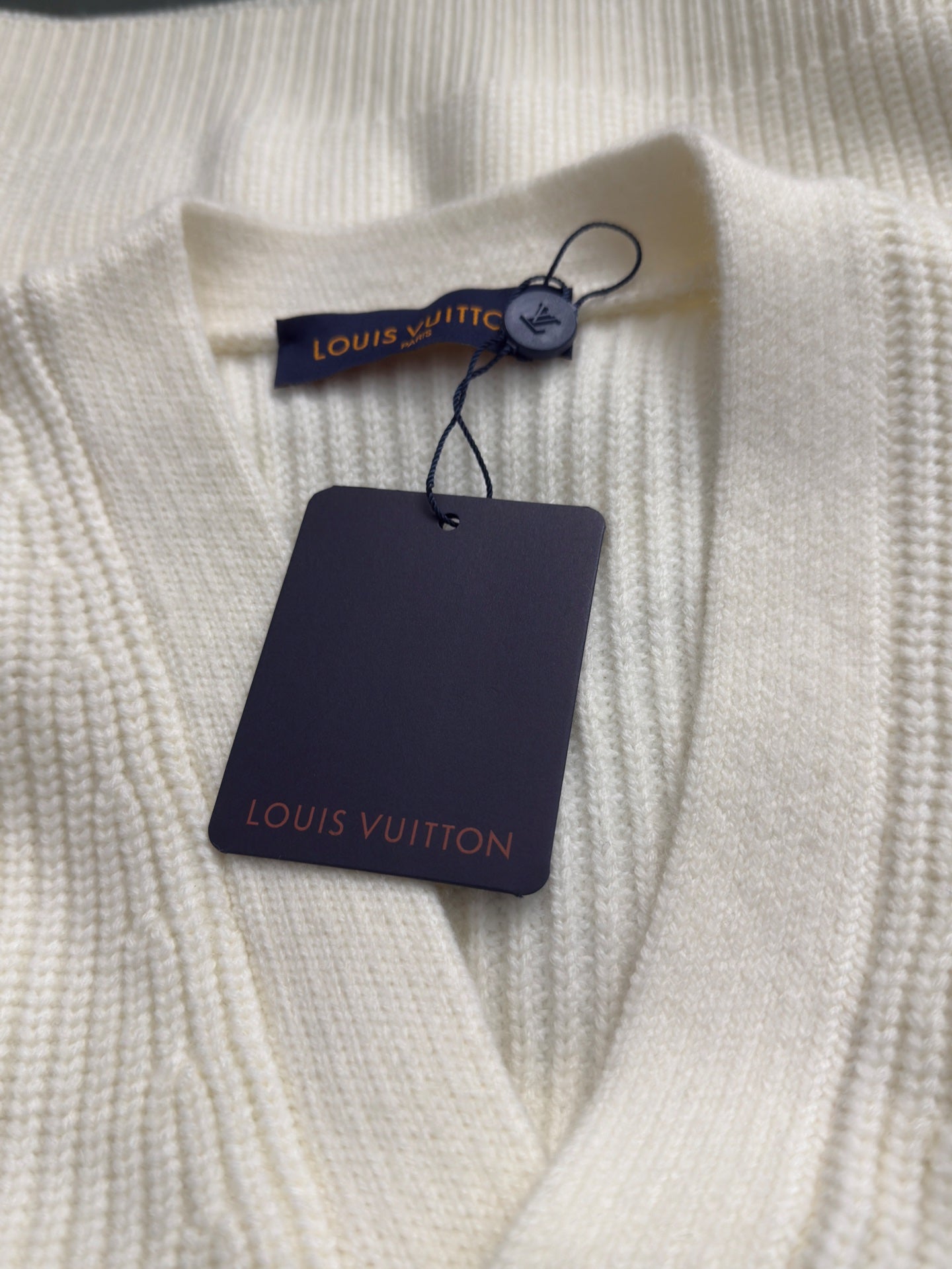 Cream rib-knit cardigan collar with brand label and navy hang tag