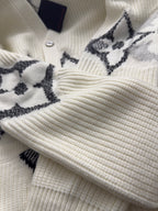 Cream rib-knit cardigan cuff with black star motif and buttoned placket