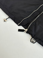 Black puffer jacket side zipper with metal pull and strap tab