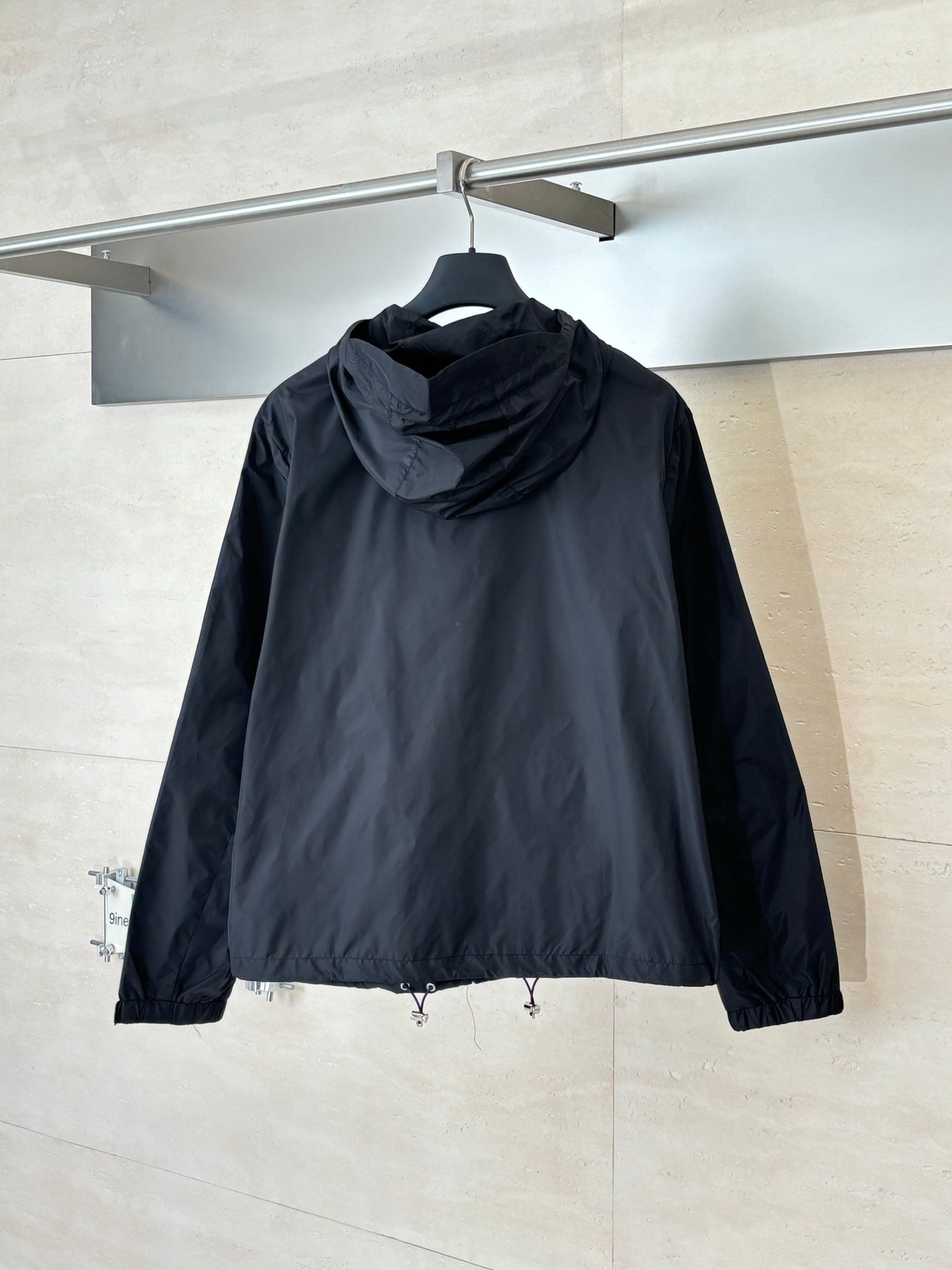Prada dark hooded jacket, back view with adjustable drawstring at hem