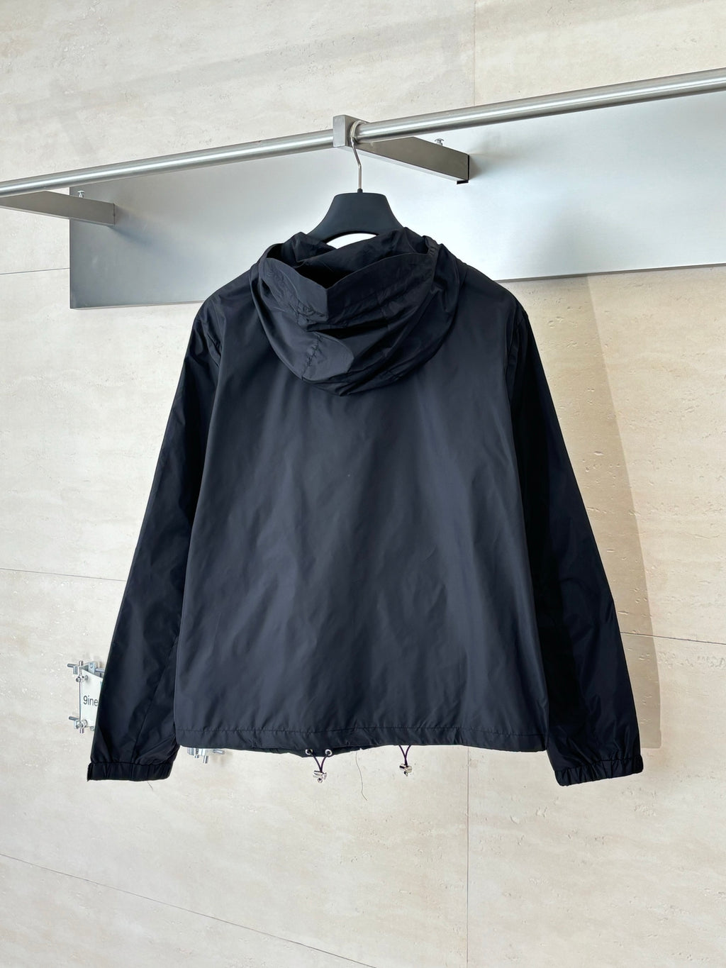 Prada long hooded puffer jacket, black, back view with drawstring hem