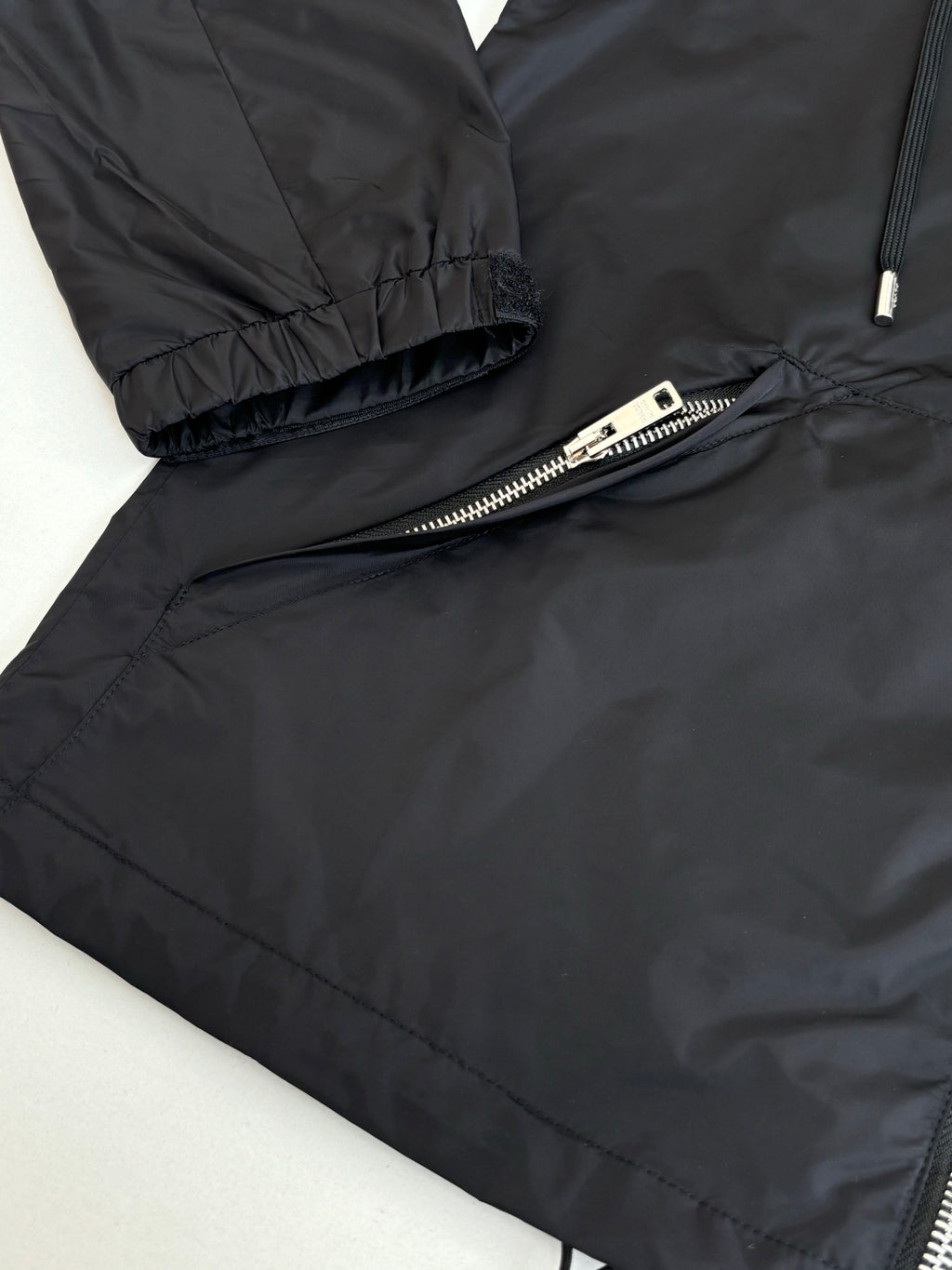 Black puffer jacket sleeve cuff and zipper detail