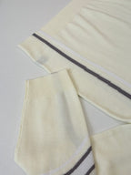 Cream knit sweater sleeves and body with navy side stripes on ribbed cuffs