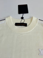 Cream crewneck sweater with embroidered side logo and hanging neck label