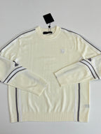 Cream long-sleeve sweater with small chest logo and navy-striped shoulder panels