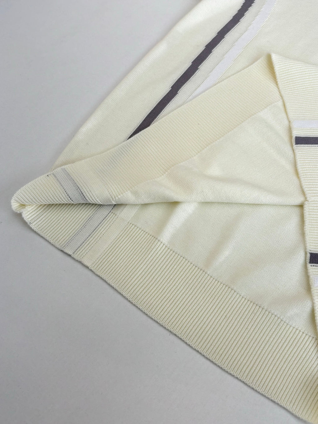 Cream long-sleeve sweater with navy and white striped sleeve trim