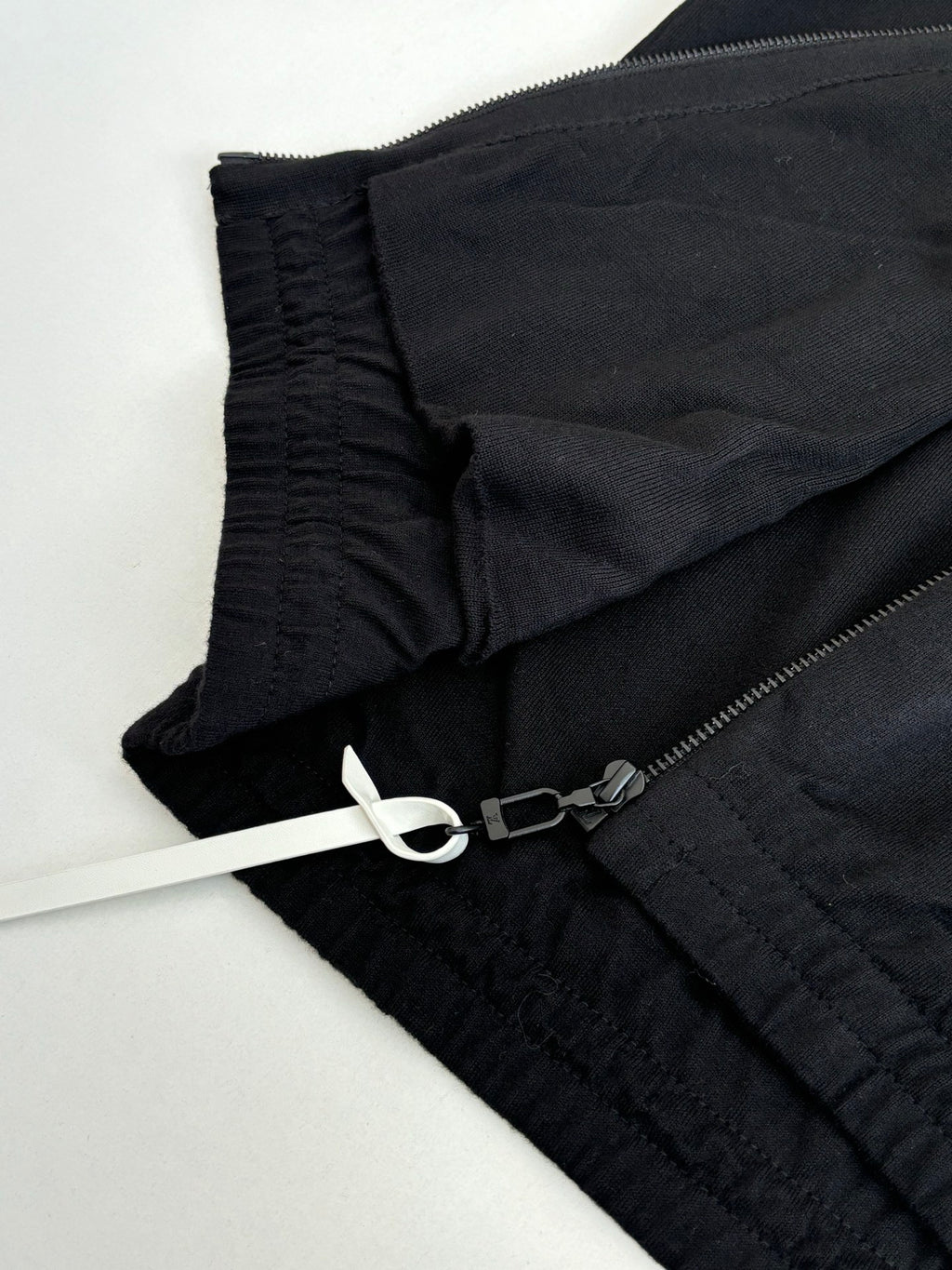 Dark navy jacket fabric detail with elastic cuff and zipper