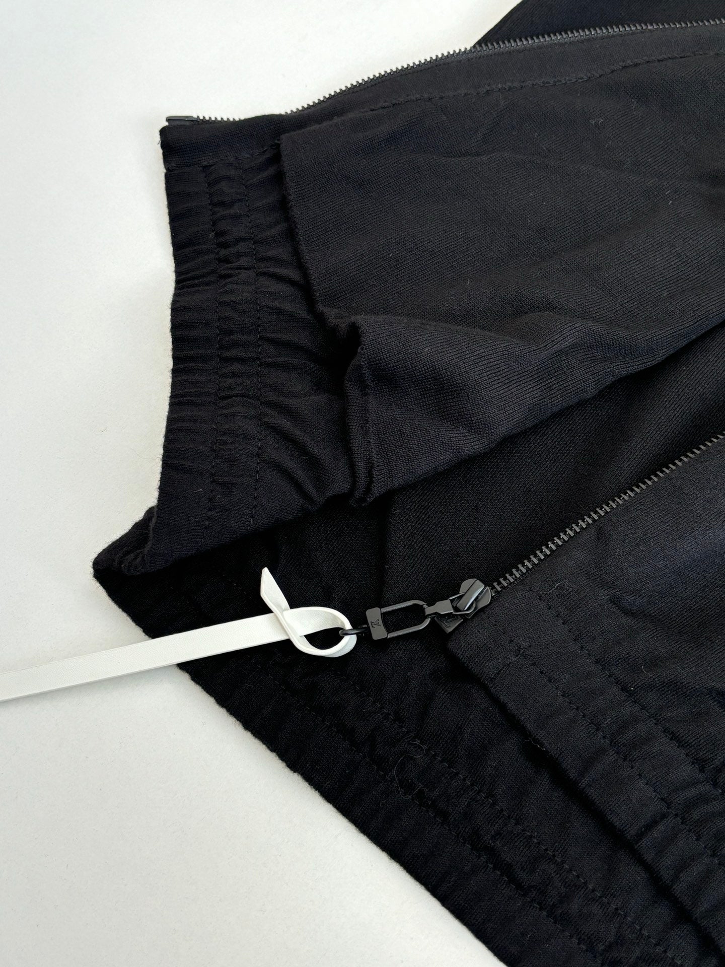 Dark navy jacket fabric detail with elastic cuff and zipper