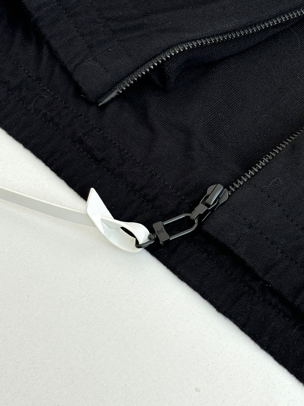 Dark navy jacket sleeve detail with zipper and embroidered cuff