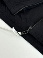 Dark navy jacket sleeve detail with zipper and embroidered cuff