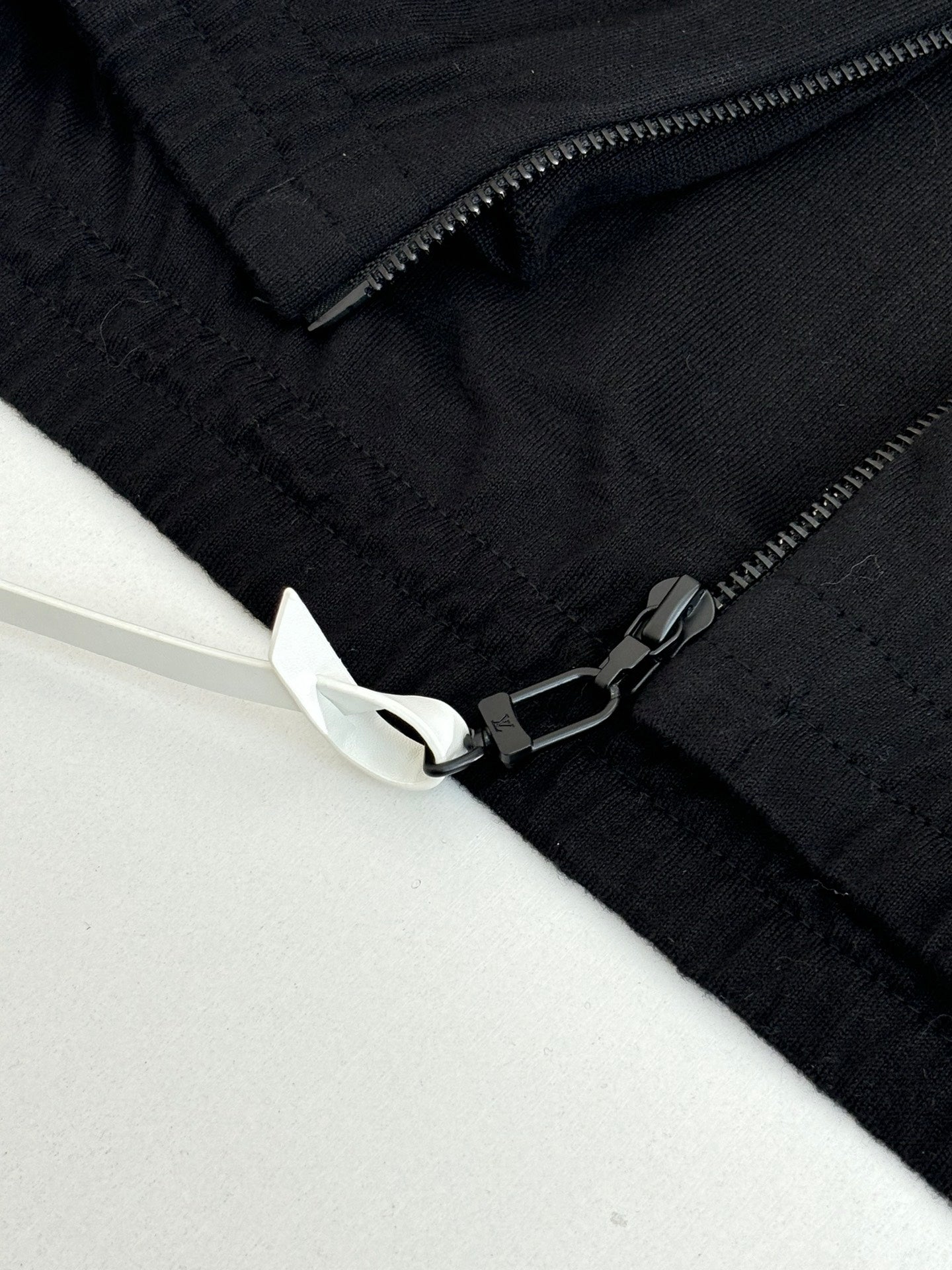 Dark navy jacket sleeve detail with zipper and embroidered cuff