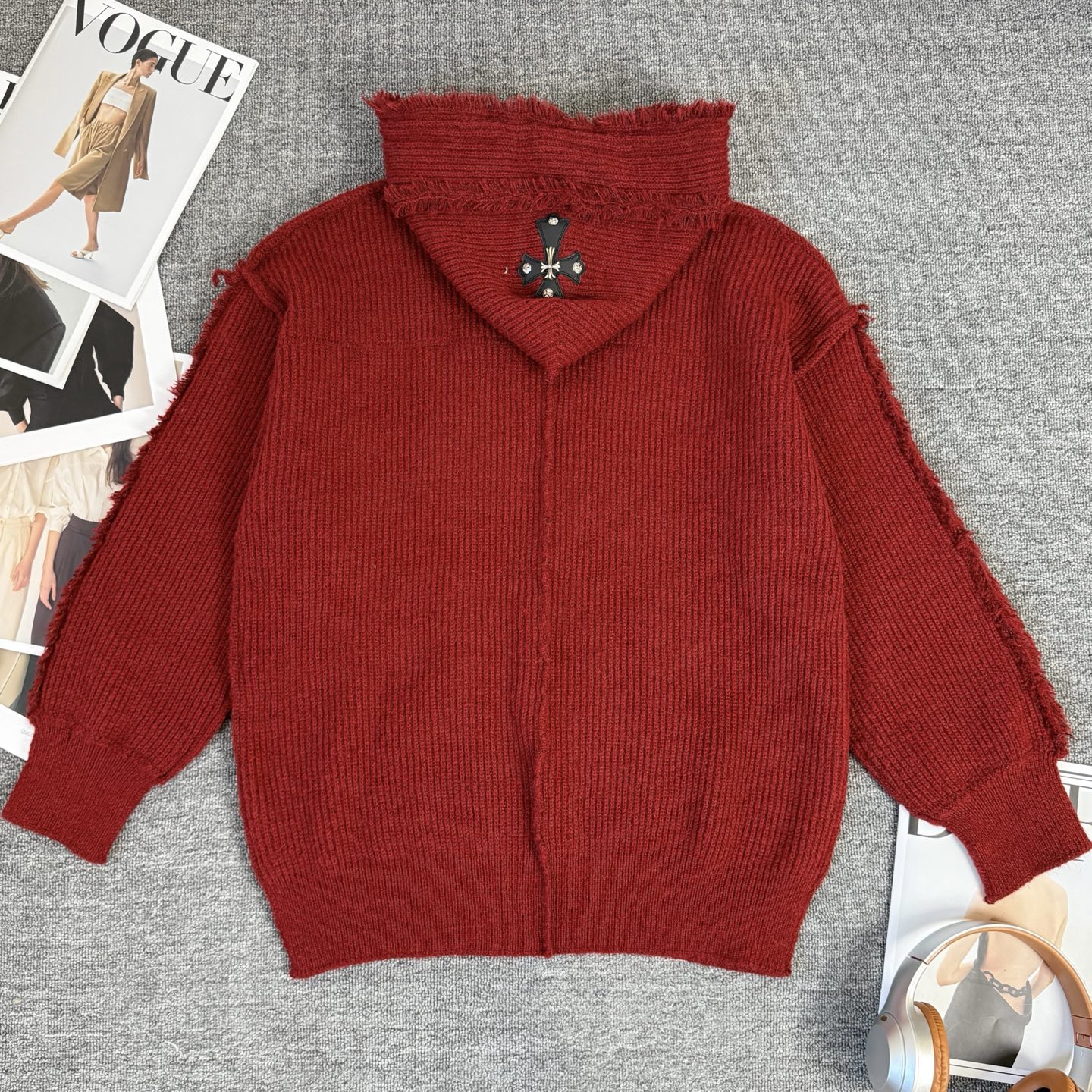 Burgundy knit hoodie with oversized hood and small logo cross emblem on chest
