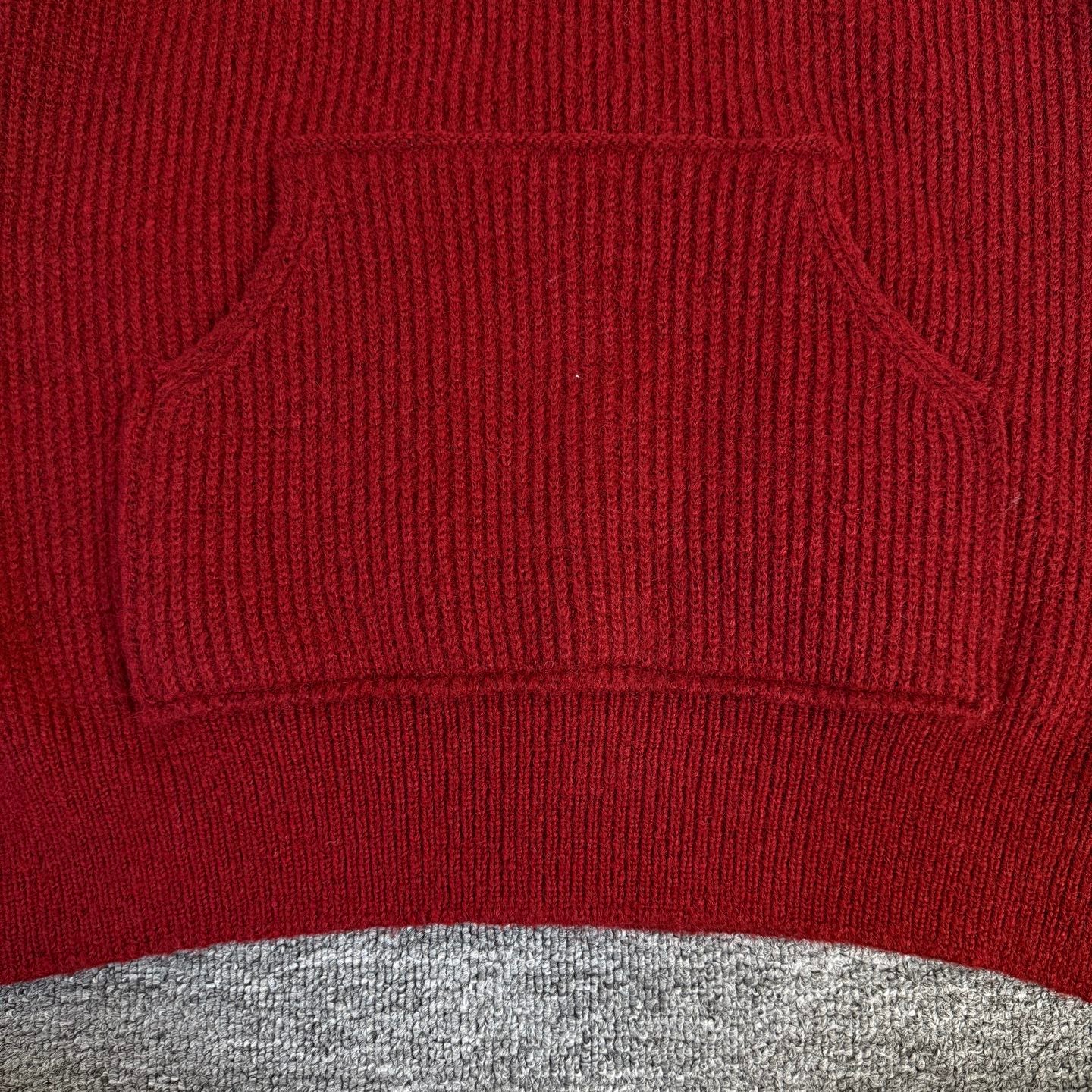 Burgundy knit hoodie with ribbed kangaroo pocket and drawstring opening