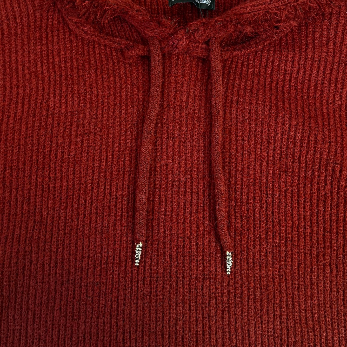 Burgundy knit hoodie close-up with drawstrings and ribbed hood front