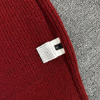 Burgundy knit hoodie interior care label near side seam