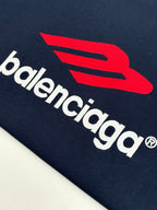 Close-up of navy long-sleeve T-shirt with Balenciaga wordmark and red symbol