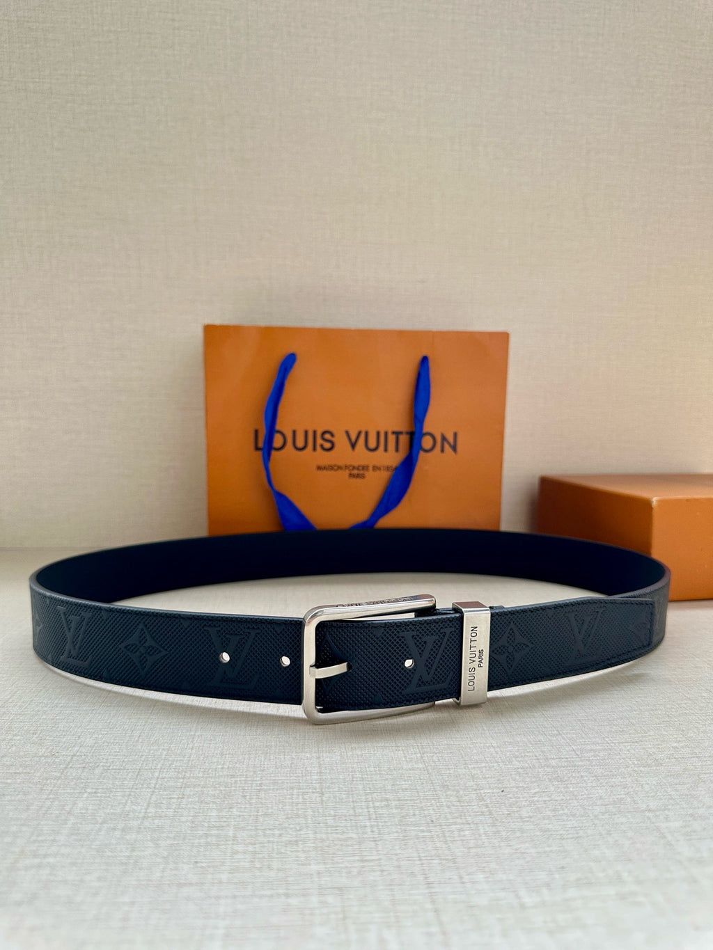 Louis Vuitton belt in dark navy with embossed monogram and silver buckle, blue tag.