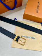 Louis Vuitton belt with gold-tone buckle and dark navy embossed strap on cream pouch.