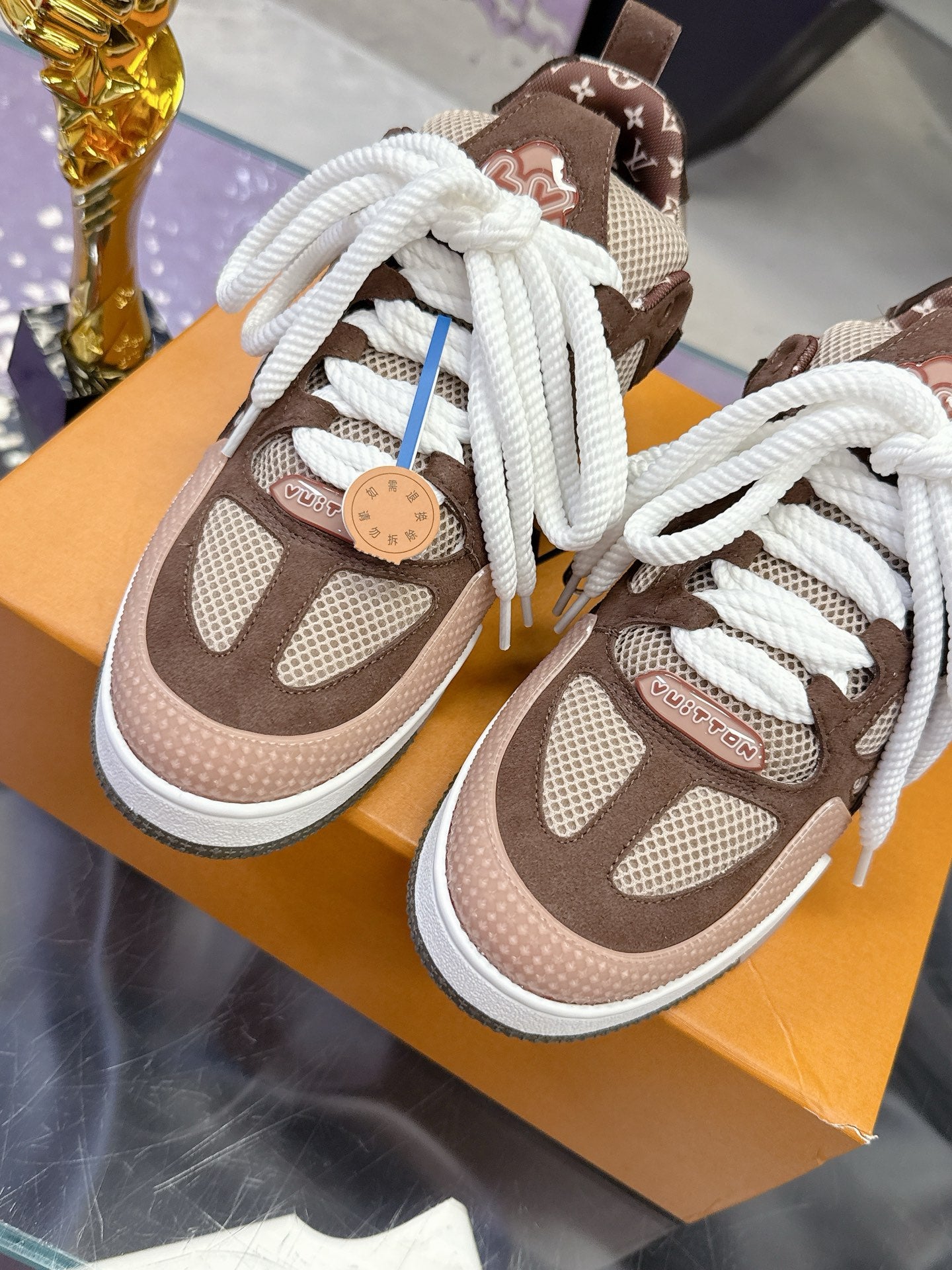 Women's Louis Vuitton low-top sneakers, front close-up, brown mesh with white laces and tag lace ties