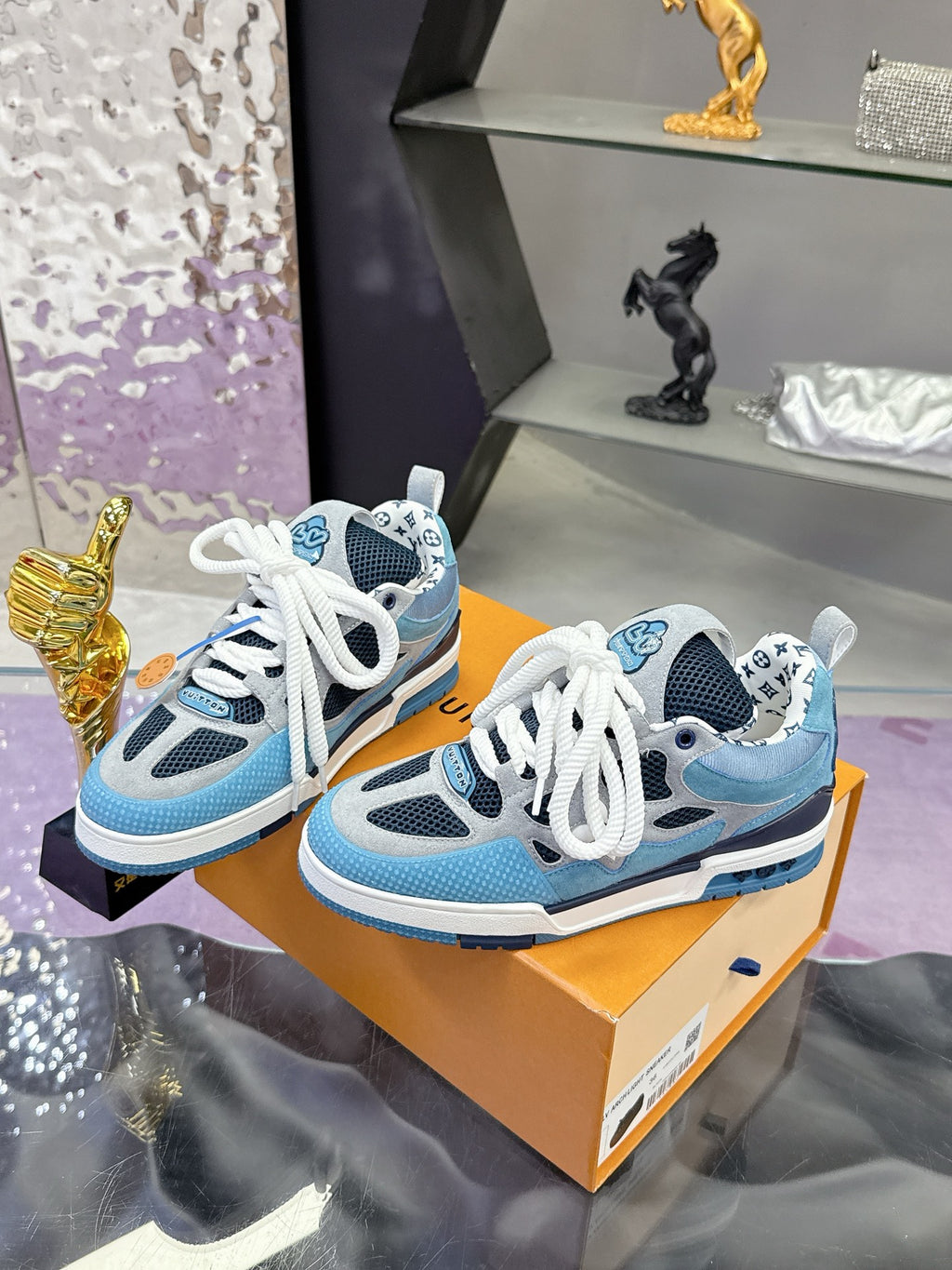 Two blue Louis Vuitton women’s sneakers on orange box, white laces visible