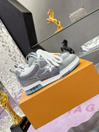 Gray low-top sneakers with white laces, perforated panels, and blue sole edge