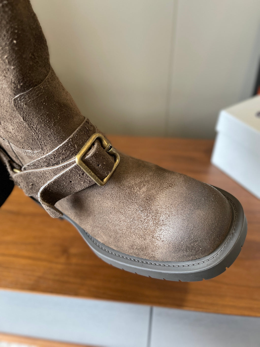Side view suede ankle boot with metal buckle strap, taupe