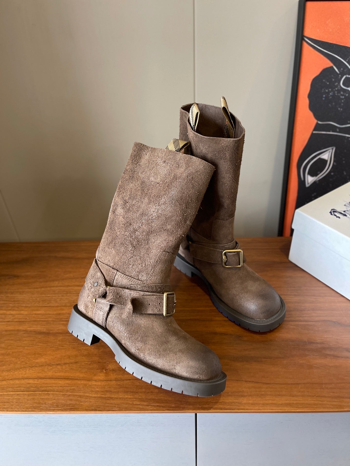 Pair of suede ankle boots with buckle straps and lug soles, taupe