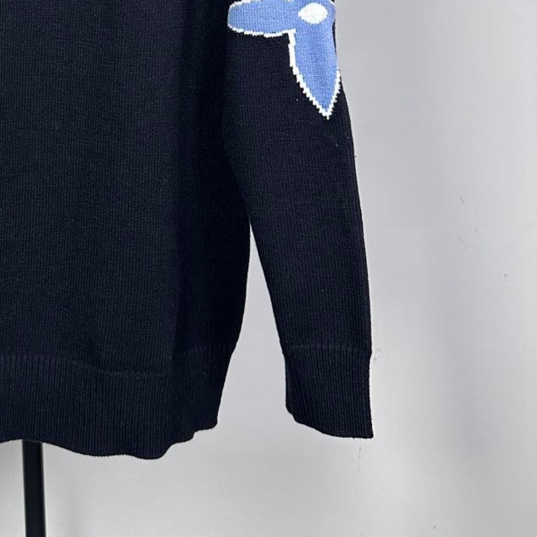 Louis Vuitton long-sleeve sweater close-up of blue LV star logo on sleeve
