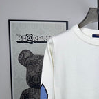Long-sleeve knit sweater in white with ribbed crew neck and blue logo on sleeve