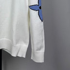 Long-sleeve knit sweater in white with blue logo on sleeve and ribbed cuffs
