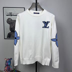 Long-sleeve knit sweater in white with blue logo motif on chest and sleeves