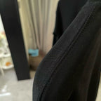 Black sweatshirt sleeve seam with textured knit fabric detail