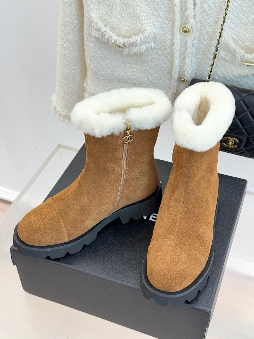Tan suede ankle boots with white plush cuffs and side zipper; chunky lug sole.