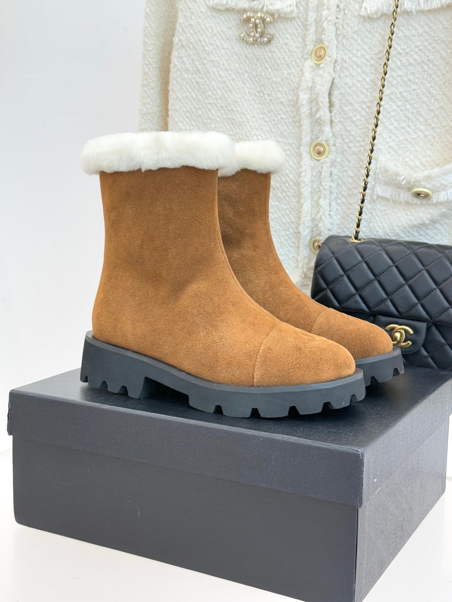 Tan suede ankle boots with white faux-fur cuff and lug rubber sole.