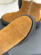 Tan suede boot with white faux-fur cuff and stitched curved toe panel.